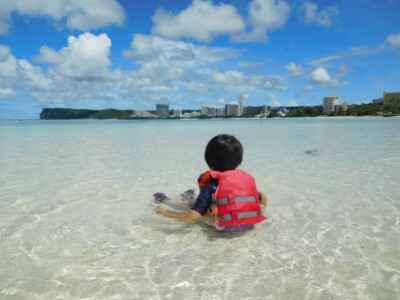 ライフジャケットを着て海を眺める子供