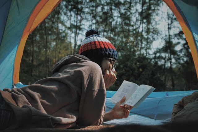 テントで本を読む女性